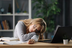 Eine Studentin schläft auf dem Schreibtisch